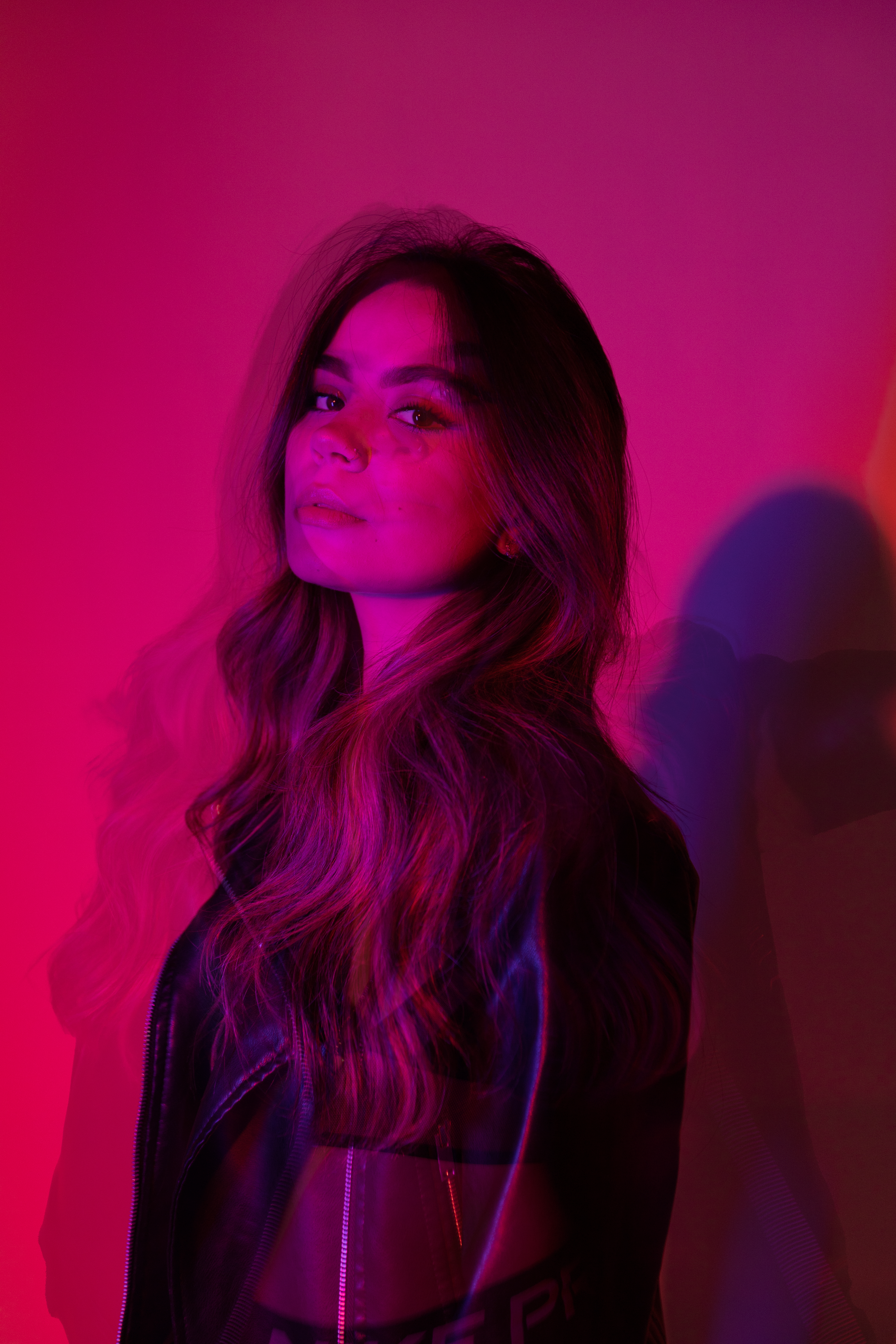 Young Woman Wearing a Leather Jacket Standing in Pink Lighting · Free ...