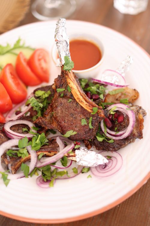 Free Savor the taste of grilled lamb chops served with fresh salad and dipping sauce. Stock Photo