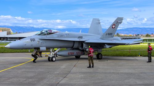 Free Swiss military jet with soldiers at Payerne Airport in Switzerland on a clear day. Stock Photo