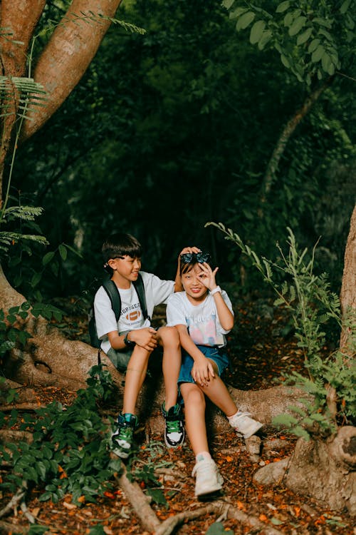 Boy and Girl Sitting in a Forest and Smiling 