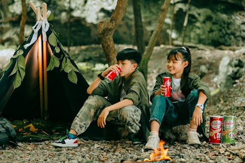 Boy and Girl Camping in Forest