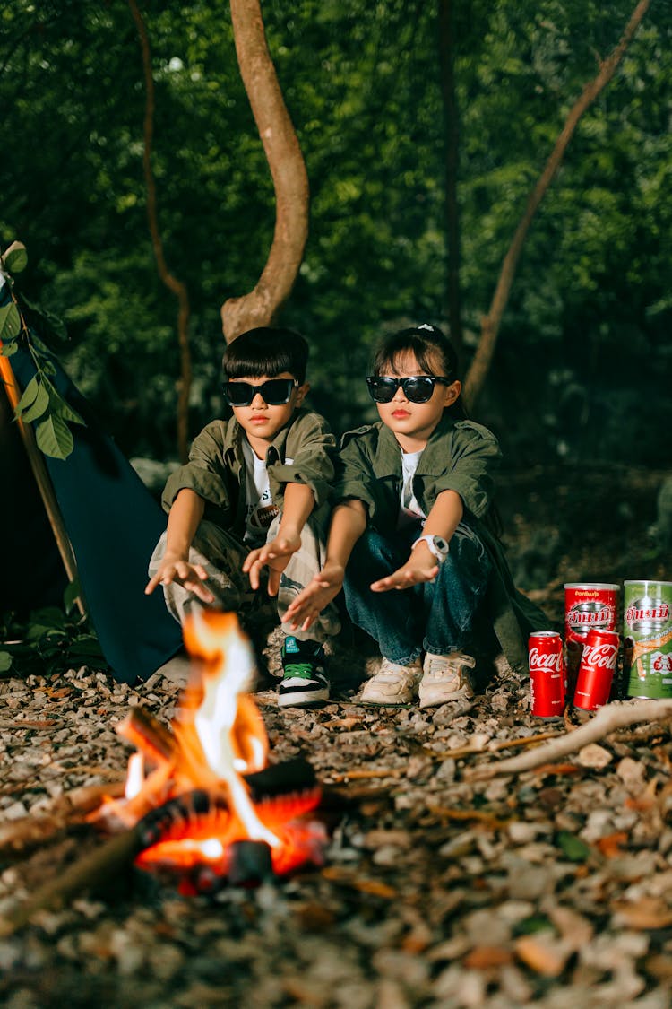 Boy And Girl Camping In The Forest By The Fire 