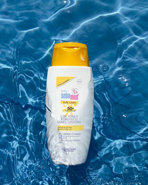 Free Bottle of Sunscreen in Water  Stock Photo