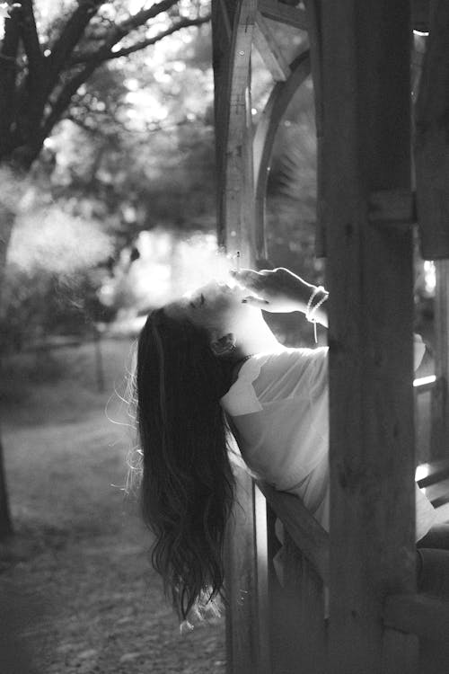 Woman Sitting in Gazebo Smoking Cigarette