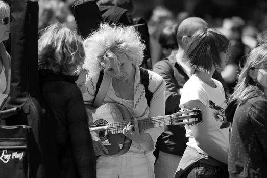 A woman playing the guitar in a crowd