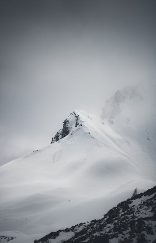 A snowy mountain with a snow covered peak