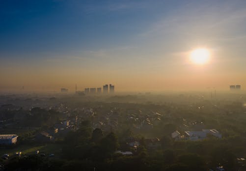 Aerial view of Sindang Jaya, Banten at sunrise, capturing the city's vibrant skyline and morning fog.