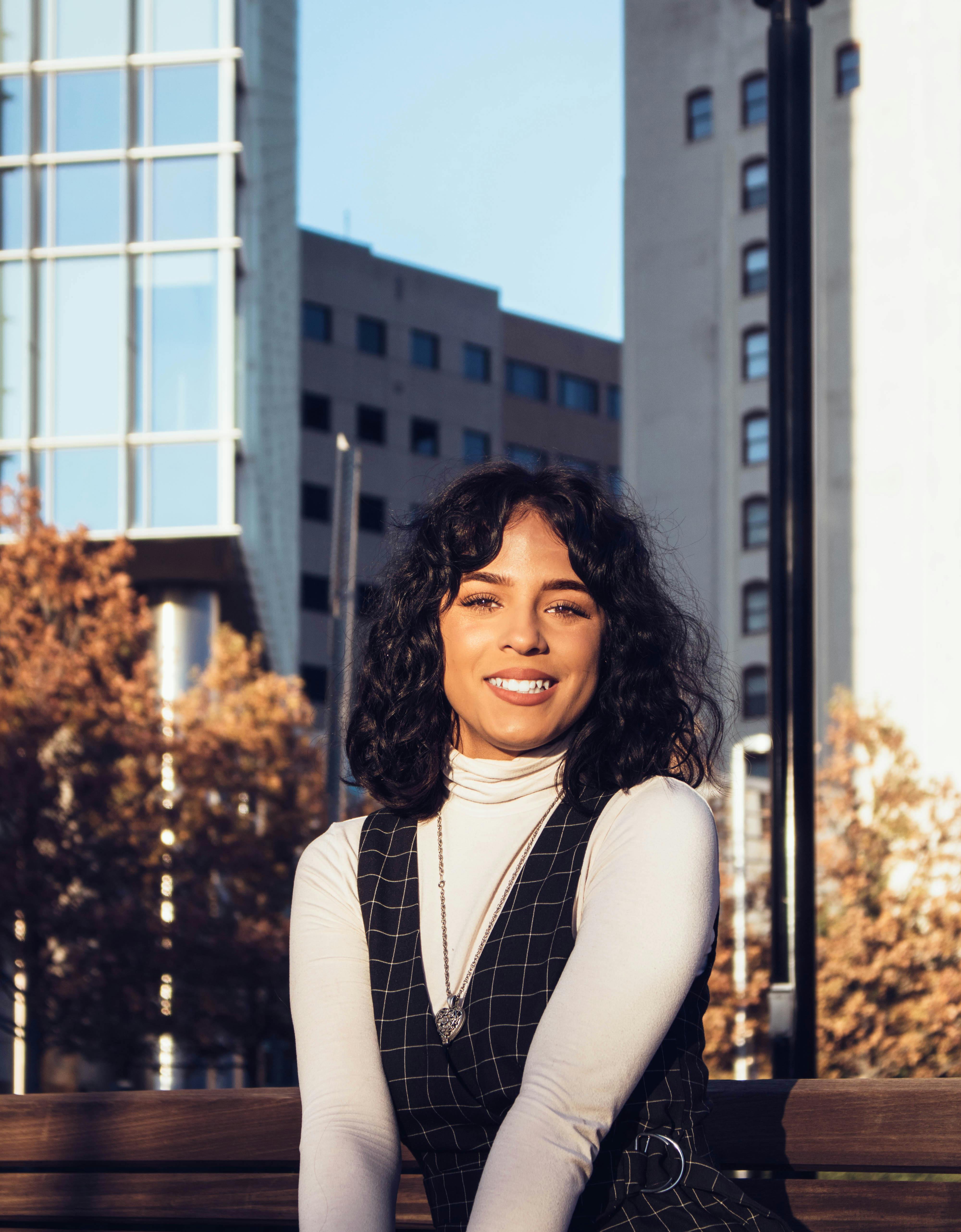 秋天，城市公园里，一位快乐的女子正对着镜头微笑