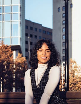 秋天，城市公园里，一位快乐的女子正对着镜头微笑