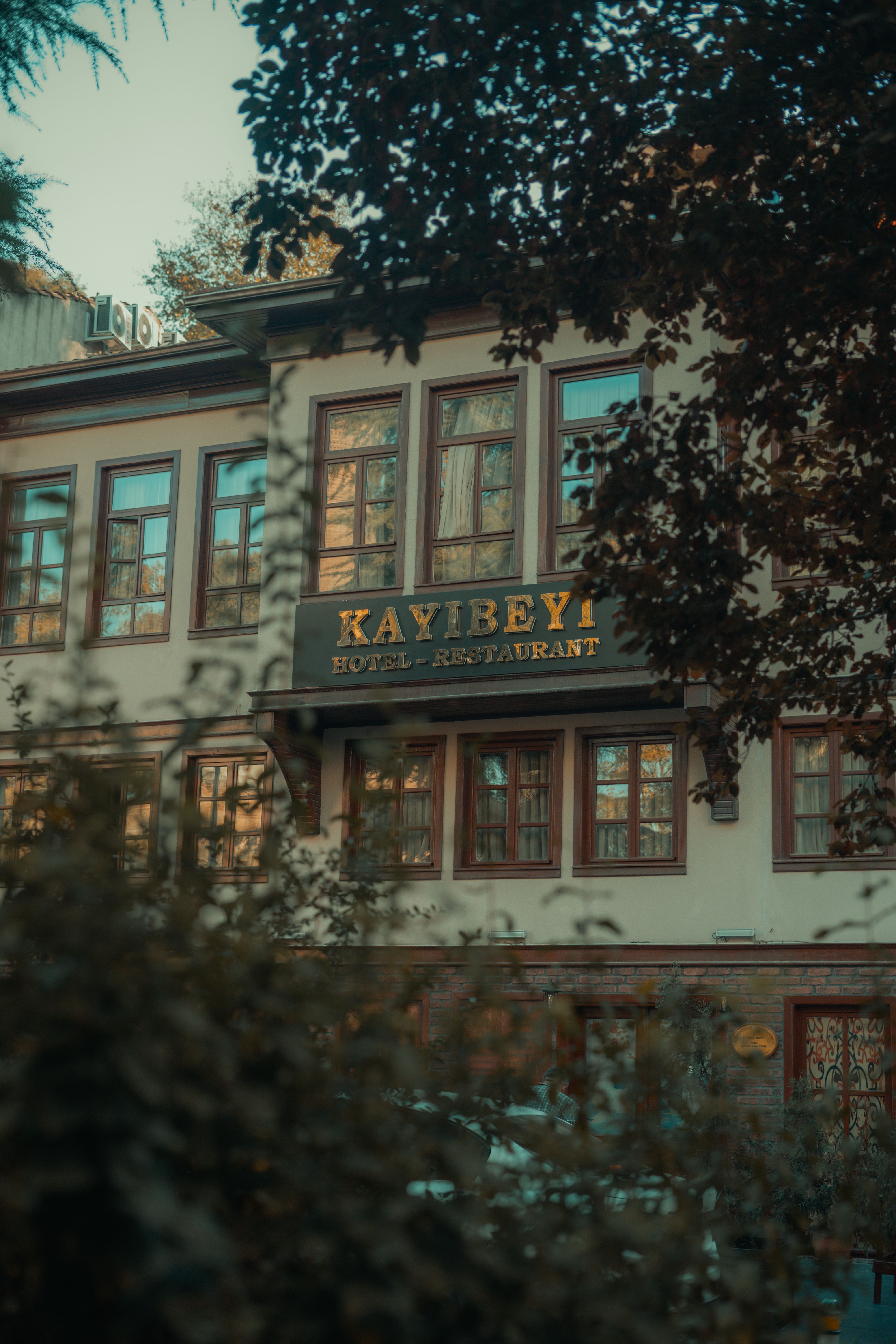 Charming view of Kayibeyi Hotel and Restaurant surrounded by trees in Bursa, Turkey.