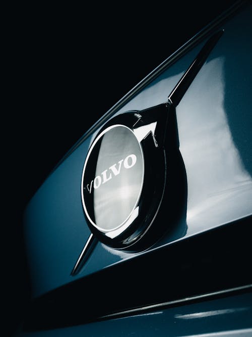 Close-Up Photo of a Shiny Volvo Emblem on a Blue Car