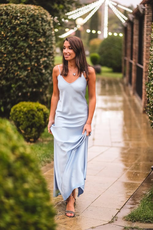 Woman in Blue Dress on Wet Pavement