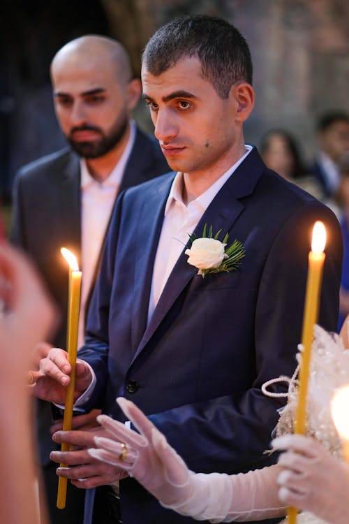 Groom Holding Candle on Wedding