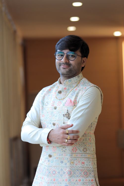 Free Smiling Indian man wearing embroidered kurta, standing indoors. Perfect for cultural and fashion themes. Stock Photo