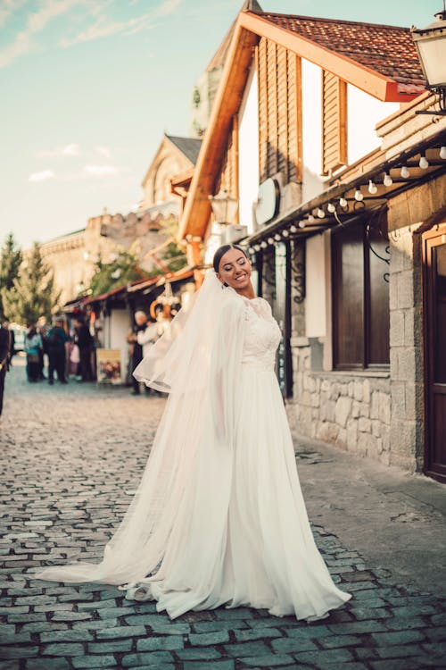 Smiling Bride in Wedding Dress Standing on Street