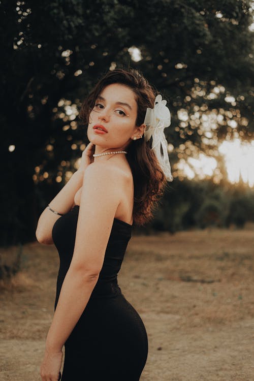 Young Woman in a Black Dress Posing Outside 