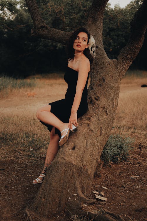 Elegant Woman Leaning against a Tree