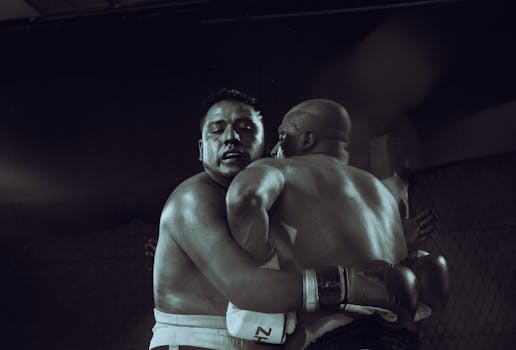 Captured moment of two boxers in a tense embrace during a match in Cuenca, Ecuador.