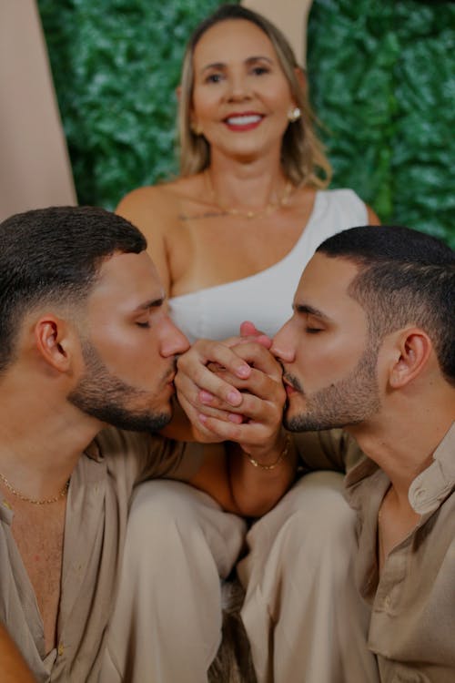 Woman Sitting with Couple Kissing Hands