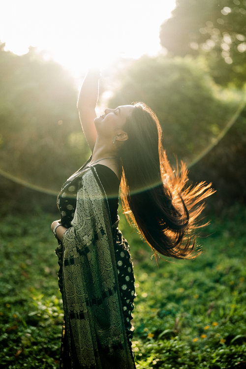Free A woman in a saree enjoying a sunny day outdoors, exuding joy and freedom. Stock Photo