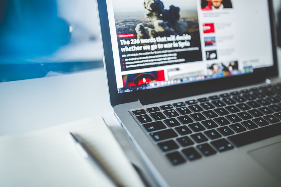 A laptop on a desk displaying an online news website