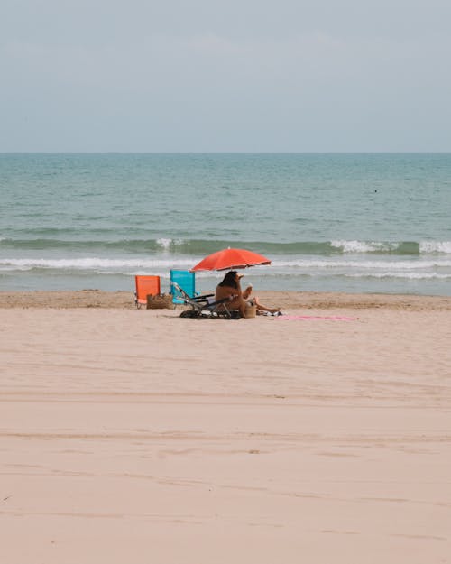 Tourist on the Beach Under a Sun Umbrella