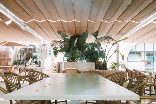 Free Charming outdoor restaurant with wicker chairs in Benidorm, Spain under a canopy. Stock Photo