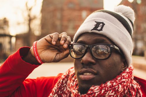 Free Close-up portrait of a man wearing a scarf and beanie with sunglasses outdoors, exuding a warm winter vibe. Stock Photo