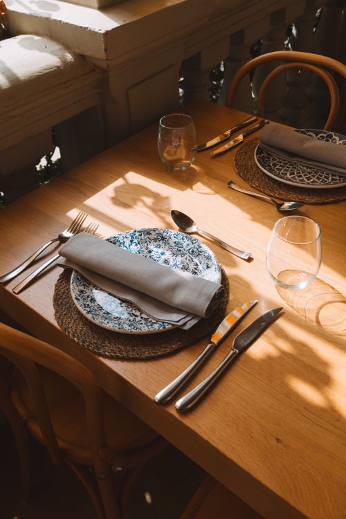 Free Sunlit table setting with elegant cutlery and plates in a Benidorm restaurant. Stock Photo