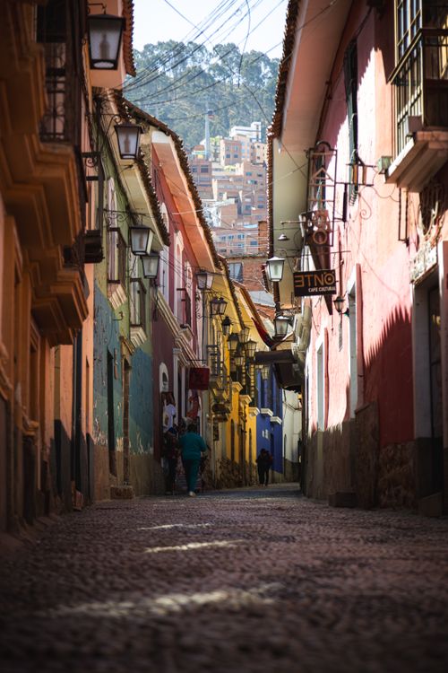 Free Discover the beauty of a narrow, vibrant street in a historic city, with colorful buildings and cobblestone pavement. Stock Photo