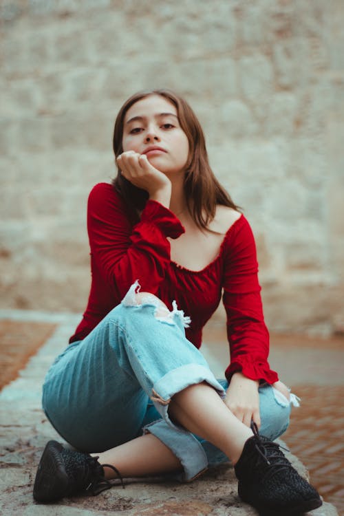 Young Woman in a Casual Outfit Sitting Outside 