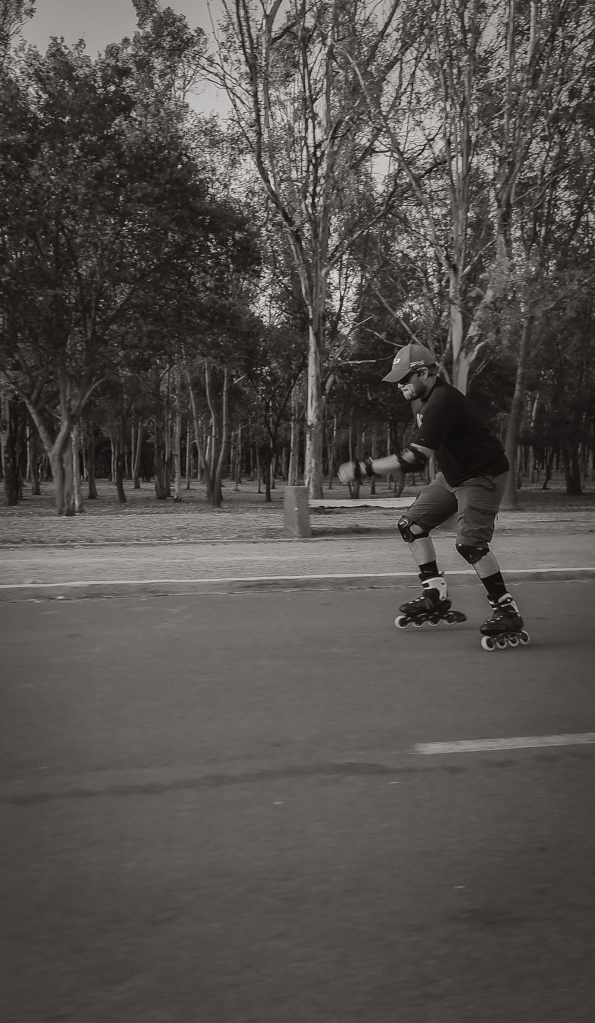 Black and white image of a man roller skating in a park in San Luis Potosí, Mexico.