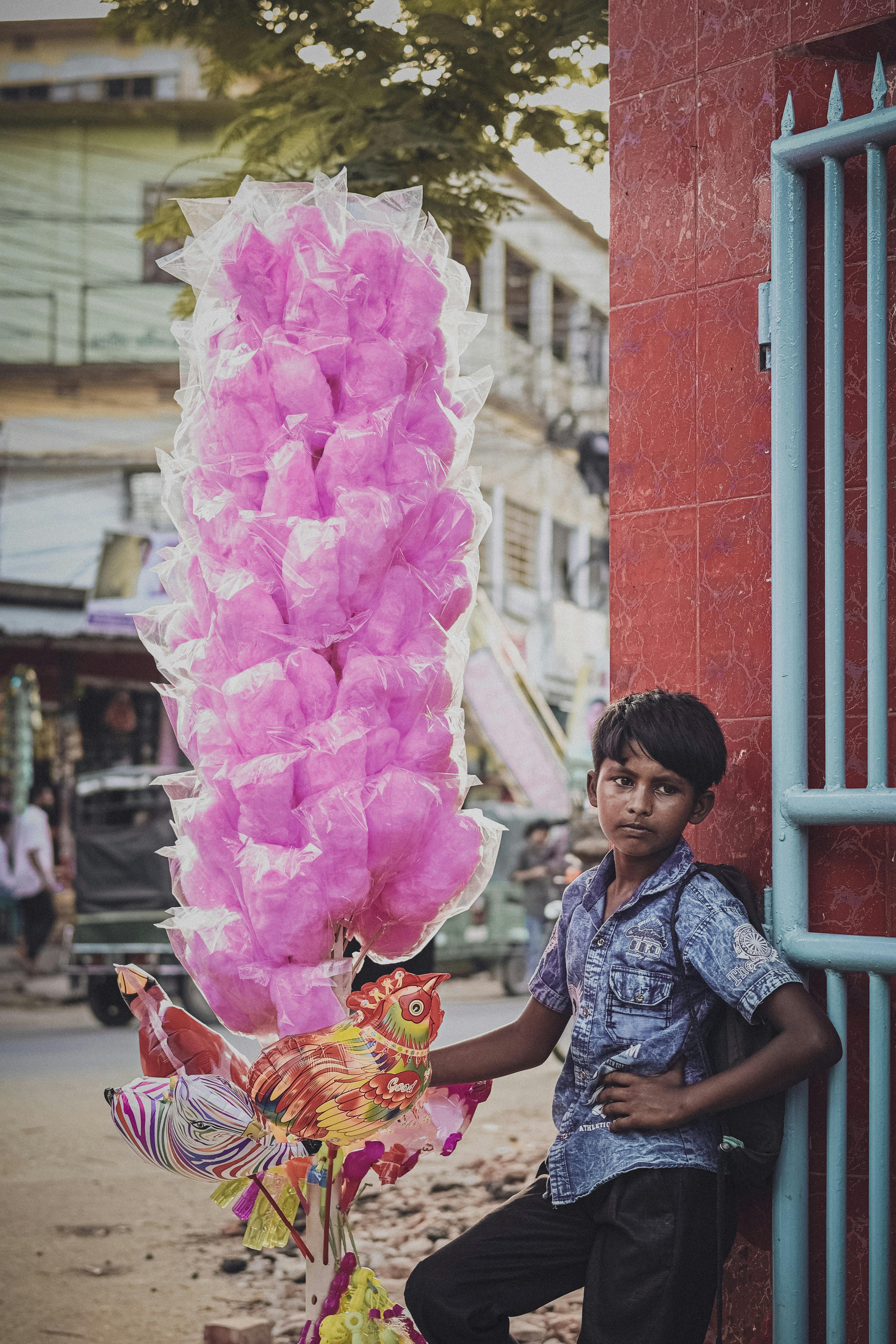 A young boy sells cotton candy on a bustling street in Pabna, Bangladesh.