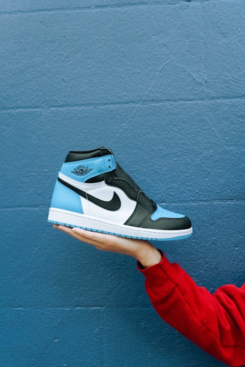 Person Wearing White And Blue Air Jordan 1's · Free Stock Photo