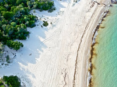 Stunning aerial view of sandy beach and turquoise ocean at Bulwer, QLD, Australia.