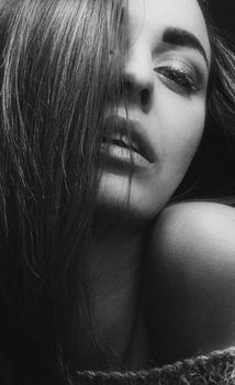 Elegant black and white glamour portrait featuring close-up of a woman's face with artistic lighting.