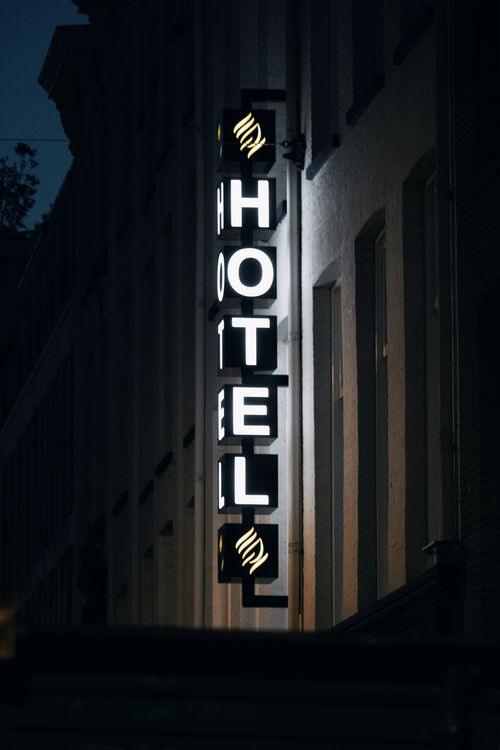 Free Neon hotel sign glowing brightly on an Amsterdam street at night, showcasing urban nightlife. Stock Photo