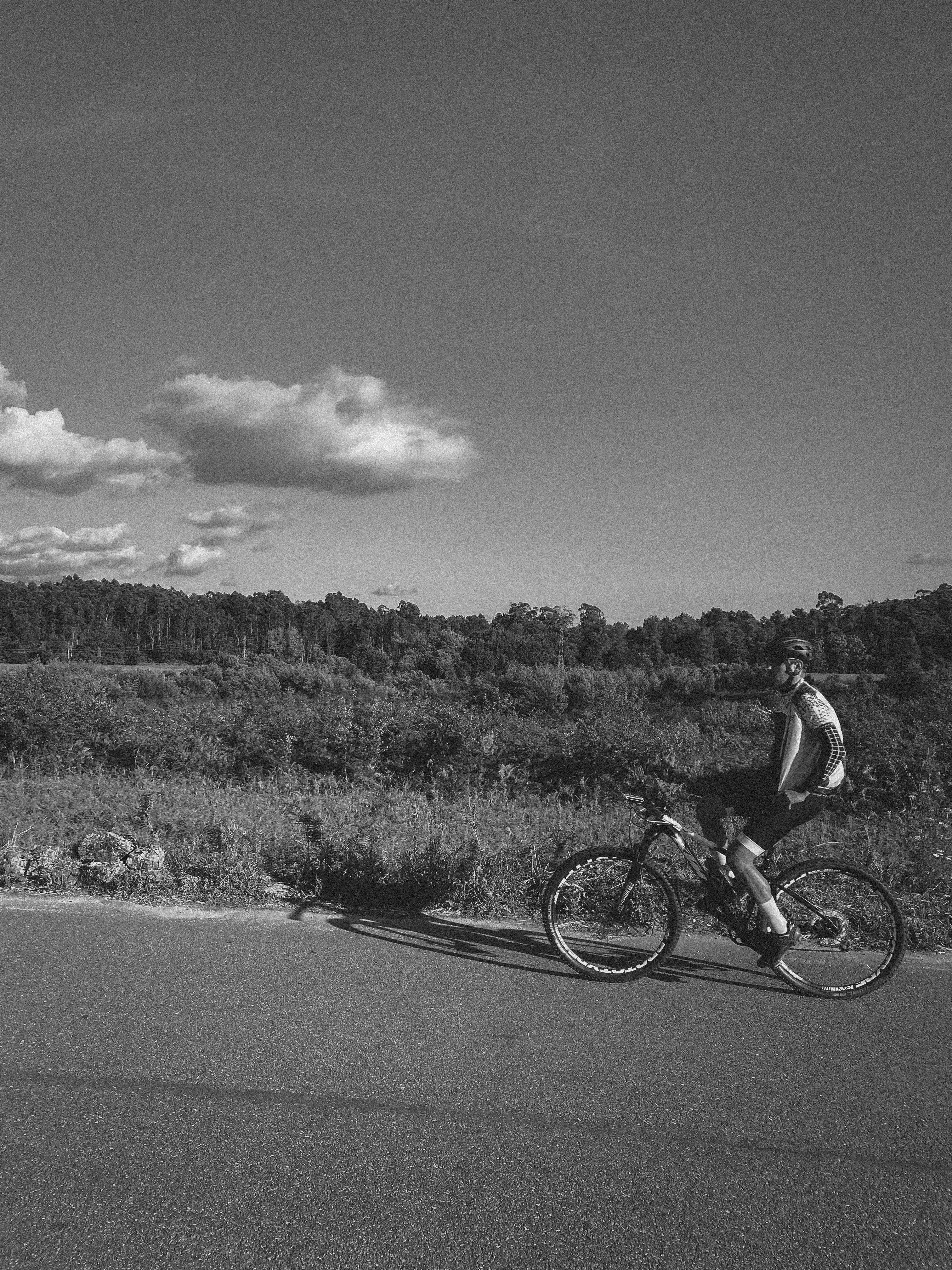 A person riding a bike on a road · Free Stock Photo