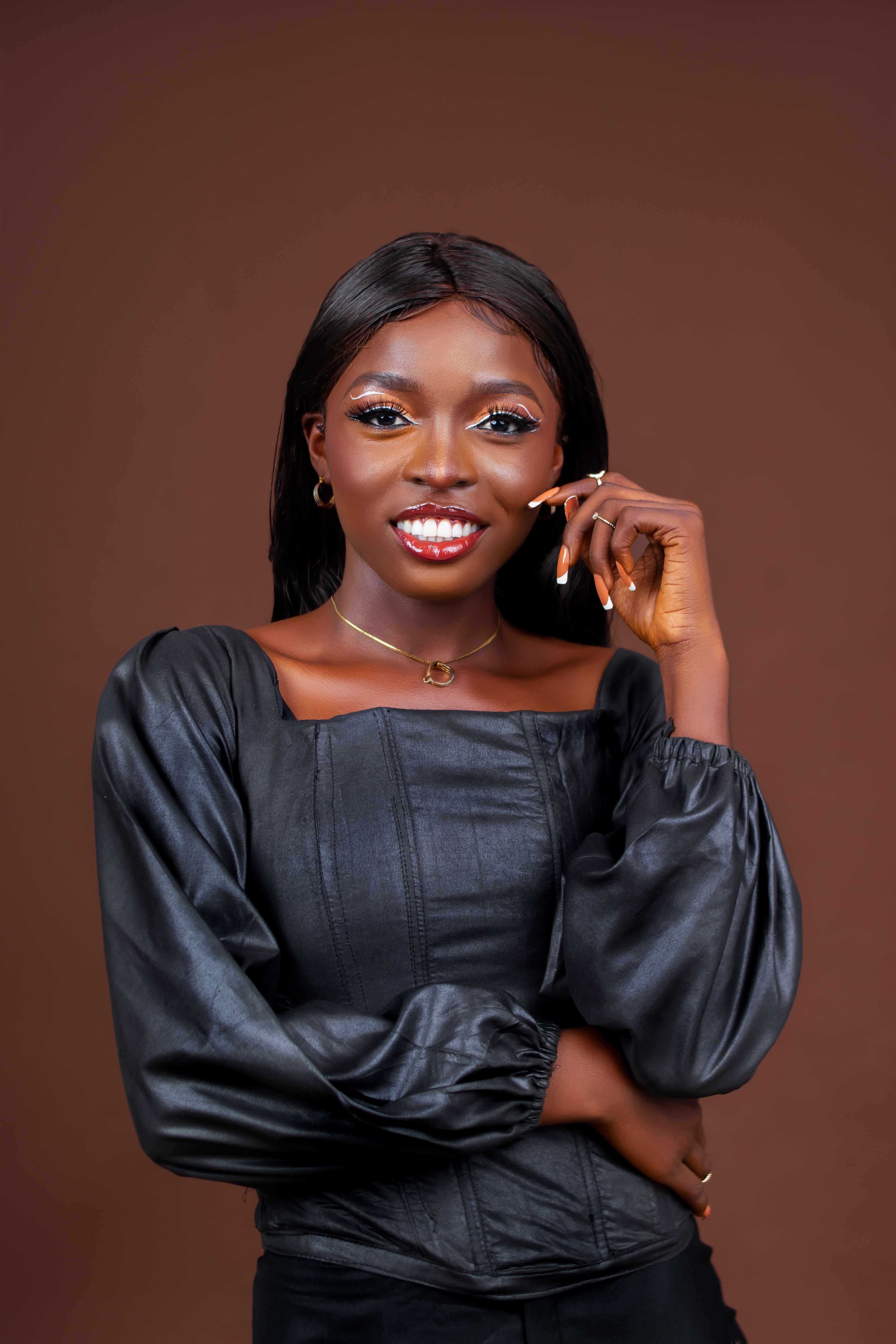 Charming woman in elegant blouse posing confidently in studio setting.
