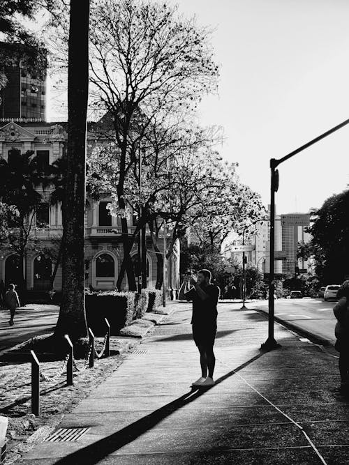Standing Man Taking a Photo in City