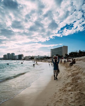 海滨景象充满活力，人们在多云的天空下享受海滩