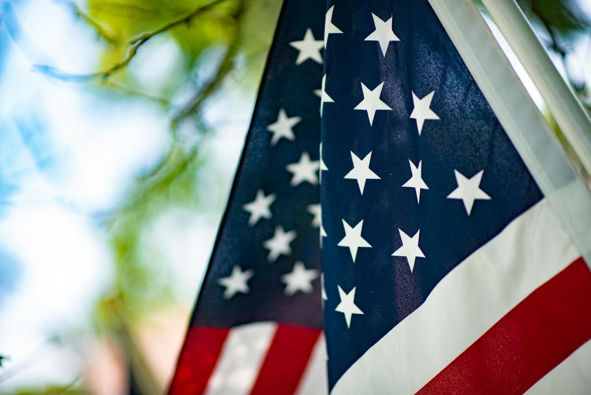 Patriotic close-up of the American flag waving in a summer outdoor setting.