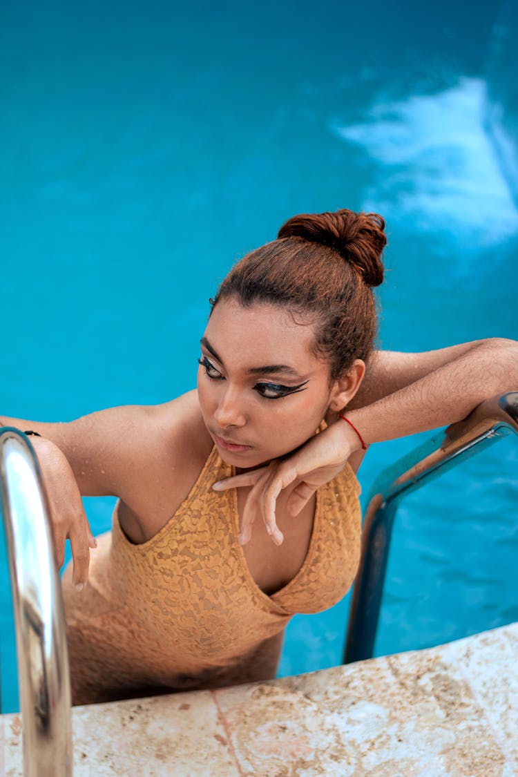 Young Woman On Pool Ladder