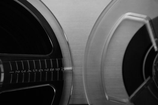 Close-up of vintage audio reel-to-reel tape in black and white.