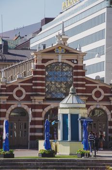 The historic Helsinki Old Market Hall with surrounding cityscape in bright daylight.