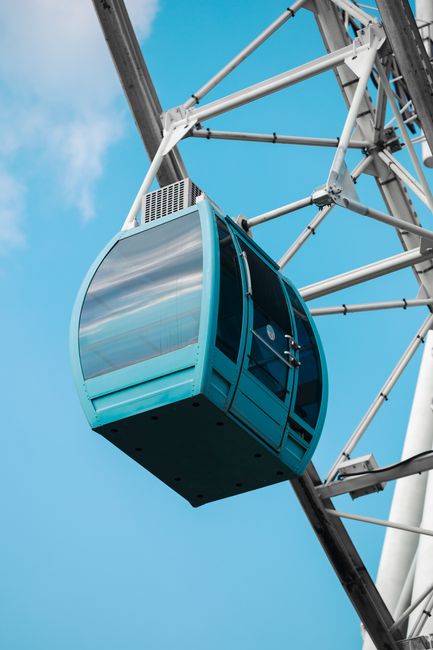 Close-up of a blue Ferris wheel gondola against clear sky, showcasing modern design.