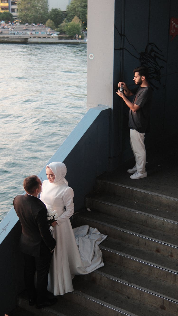 Newlyweds And A Photographer Taking A Picture Of The Bay