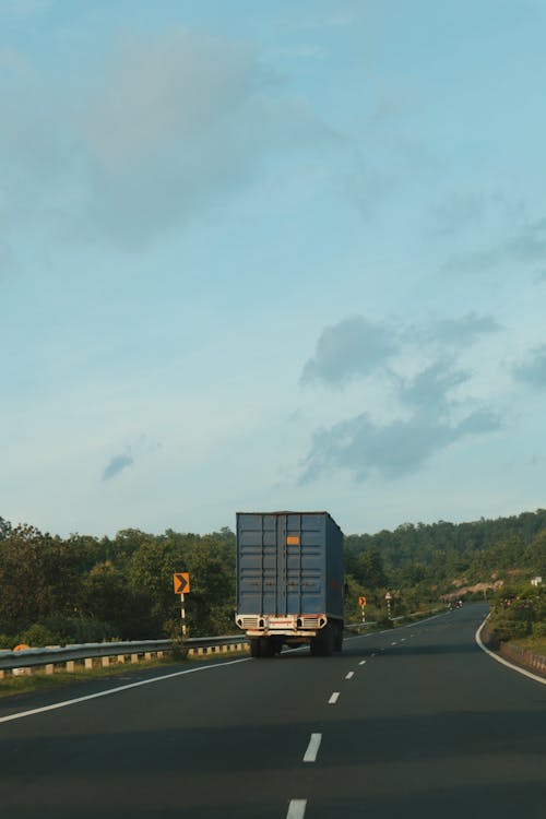 Free Container Truck Driving on an Empty Highway Stock Photo