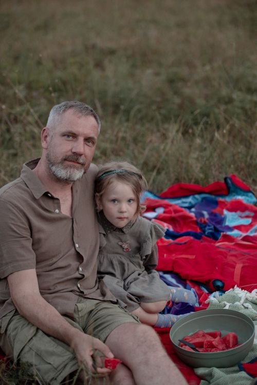 Free Father and young daughter share a peaceful picnic in a rural meadow on a warm day. Stock Photo