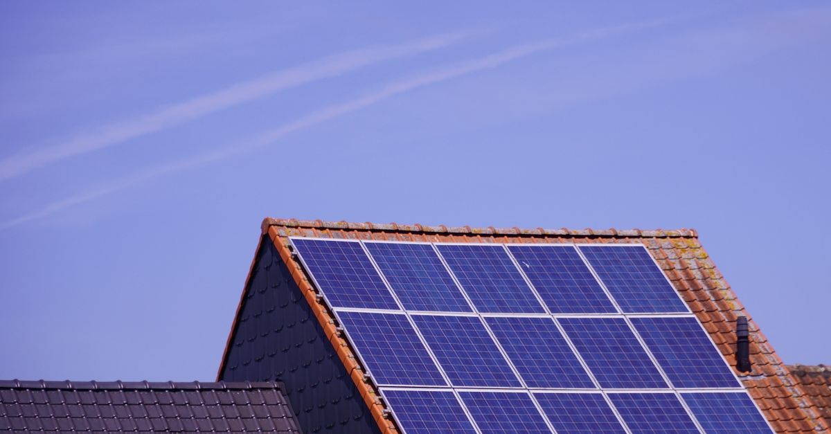 Nahaufnahme von Solarmodulen auf einem Ziegeldach unter klarem Himmel